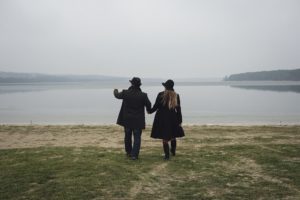 Romantic young couple approaching a lake