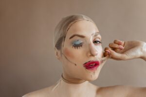 Lady does not want to wear makeup and tears nylon stocking on her face with painted red lips